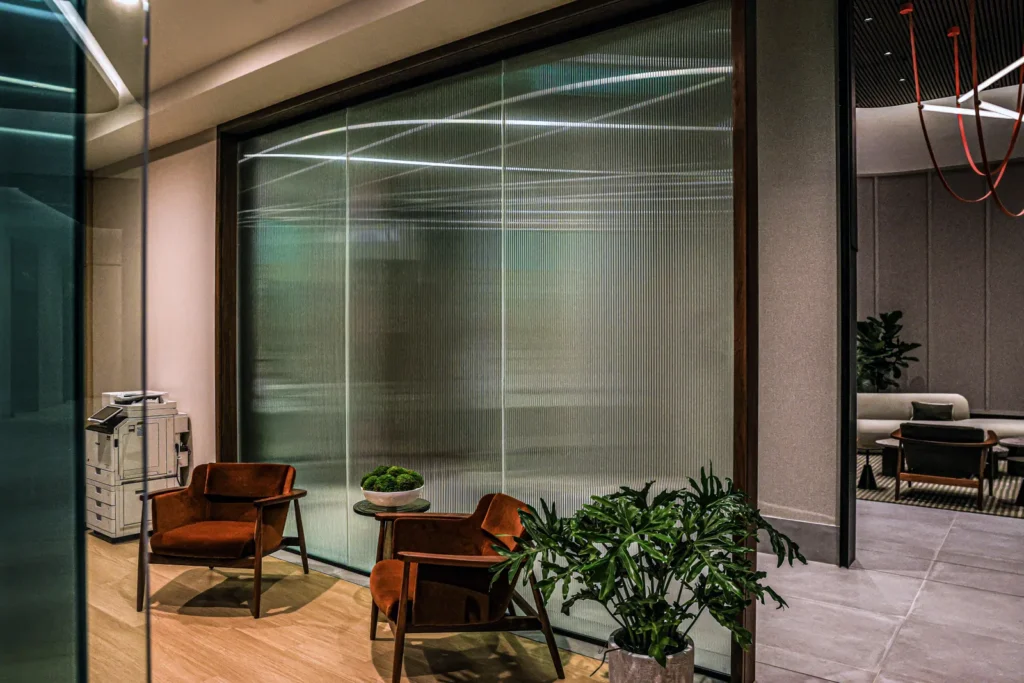 Commercial seating area beside large patterned glass windows