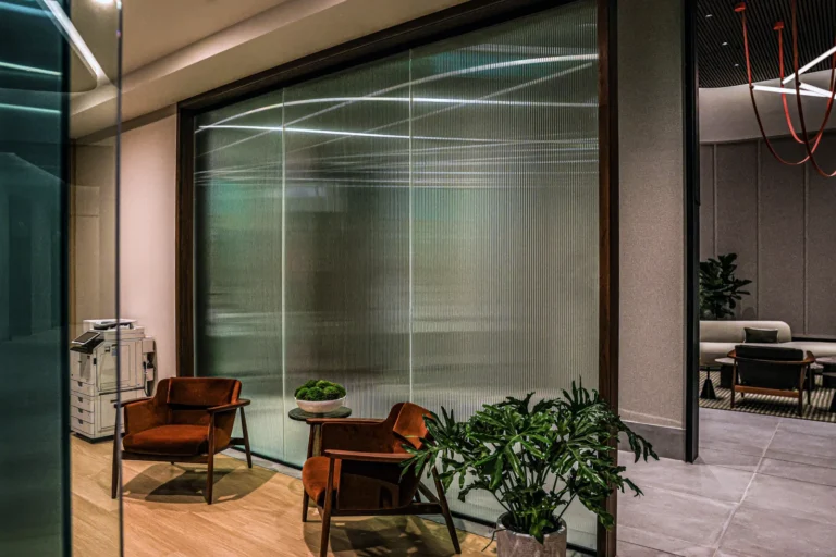 Commercial seating area beside large patterned glass windows