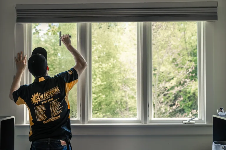 Sun Stoppers installer working on a large residential window